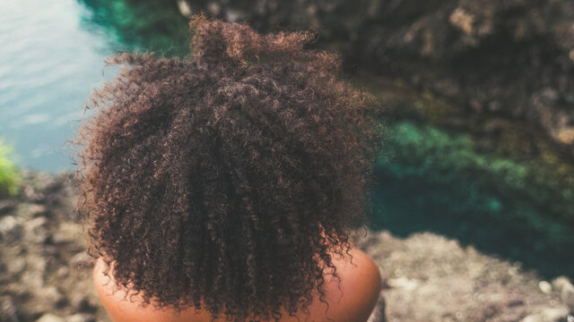 Black woman with afro hair on a Caribbean cliff (Martinique)