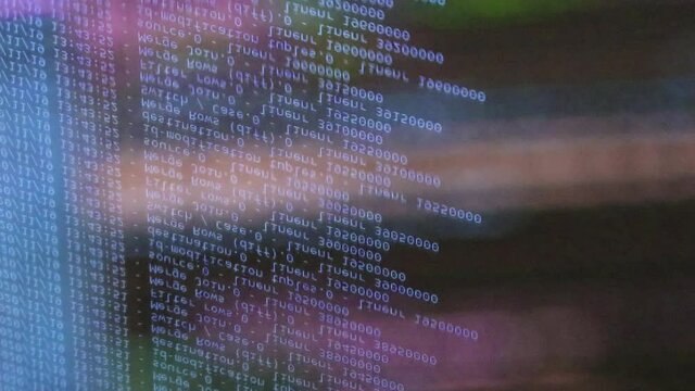 blue computer software code moving on a black monitor reflect on glass. Abstract computer hacking in process with rack server base, dynamic text running and flowing on pc screen