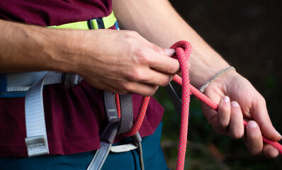 rock climber wearing safety harness with Rope with Climbing eight knot