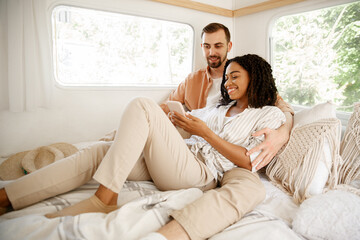 Love couple embraces in rv bed, camping in trailer