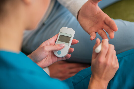Close up picture of humans hands and glucometer