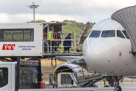 Sabiha Gokcen Airport, Istanbul, Turkey - February 16 2020: People with reduced mobility boarding to an airplane from Turkish Ground Services ambulift truck in the airport tarmac. Front view.