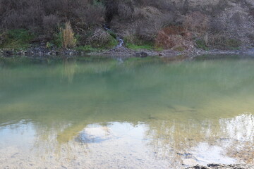 lake with reflection of autumn trees and blue sky