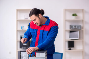 Young male repairman repairing computer