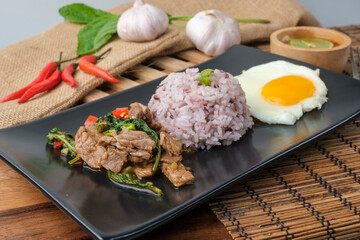 Stir-fried beef basil with fried egg and riceberry rice.