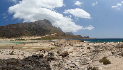 
sea ​​shore and waves on the surface and rocks on the shore during the day and clouds in the sky