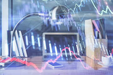 Stock market graph on background with desk and personal computer. Multi exposure. Concept of financial analysis.