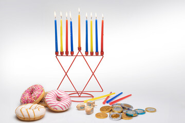 Hanukkah background, menorah candles, donuts, chocolate coins, dreidel.