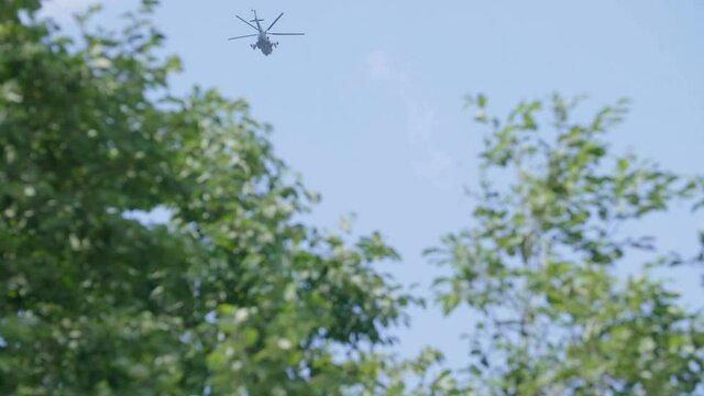 Helicopter on blue sky and trees background. Military equipment.