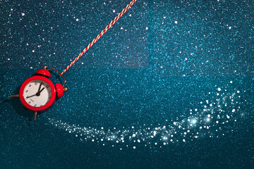 New Year banner with a red alarm clock on a blue shiny background, snow. 