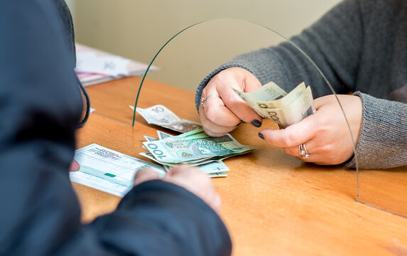 She is giving cash money to male customer. The employee receives a salary.