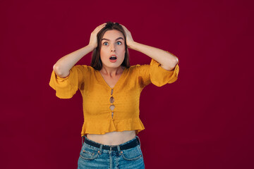 Horror, stress, shock. Female half-length portrait isolated on red studio. Young emotional...