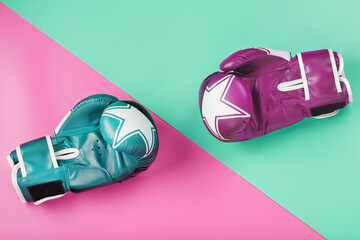 A pair of blue and pink boxing gloves on a blue and pink background.