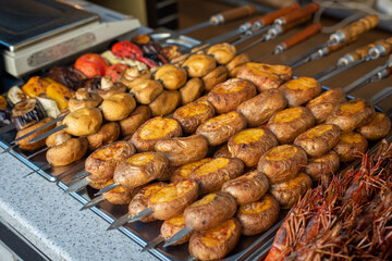grilled potatoes vegetables and mushrooms in an iron tray
