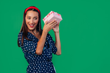 Portrait of a woman in a blue dress holding a gift box near her