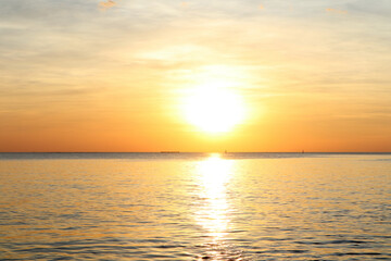 Obraz premium landscape photo of sunset reflect over the sea with clouds in the sky at the beach with shadow of rocks in the summer at Pattaya beach Thailand
