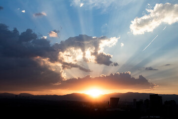 Picture of a sunset in a cloudy evening in the big city of Mexico.