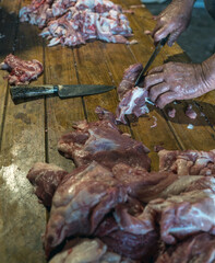 Butcher hands cutting raw meat