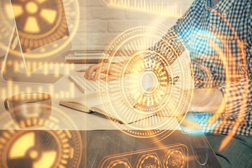 Technology theme hologram with man working on computer on background. High tech concept. Double exposure.