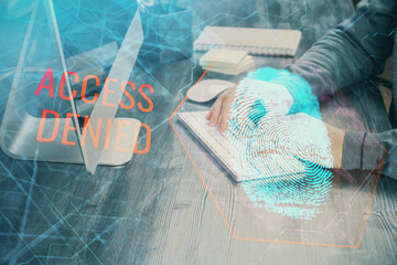 Fingerprint hologram with businessman working on computer on background. Security concept. Double exposure.