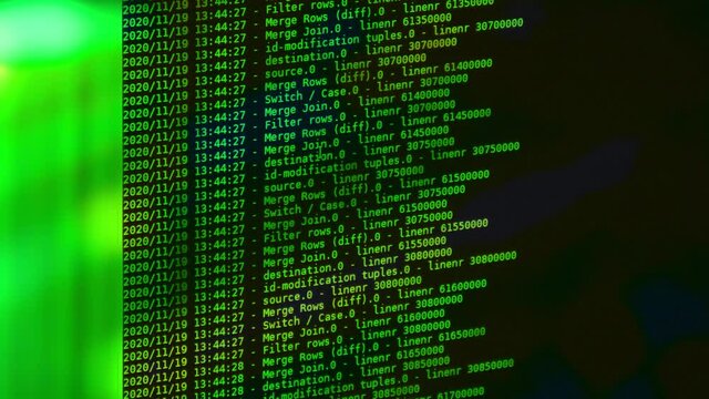 Green computer software code moving on a black monitor. Computer hacking in process, dynamic text running and flowing on pc screen.