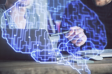 Businessman with computer background with brain theme hologram. Concept of brainstorm. Multi exposure.