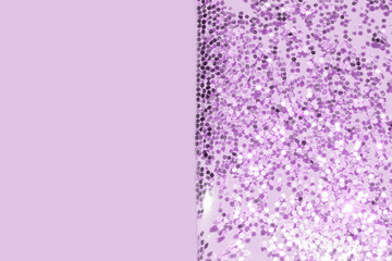 transparent liquid with purple glitter pouring over a pastel background