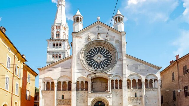 Time lapse of Modena's cathedral or church in Italy during a sunny cloudy day. There is the medieval stone bricks  in close up
