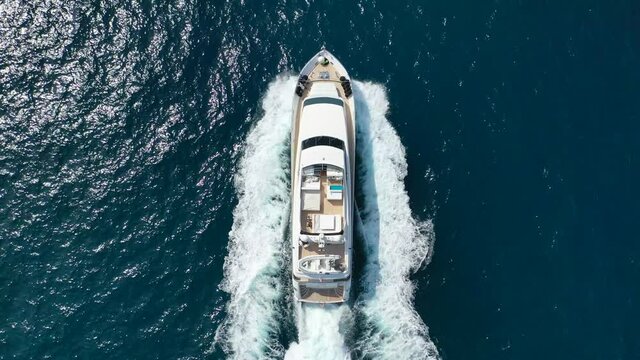 Aerial drone tracking video of luxury yacht cruising in deep blue Aegean sea, Greece