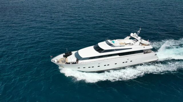 Aerial drone tracking video of luxury yacht cruising in deep blue Aegean sea, Greece