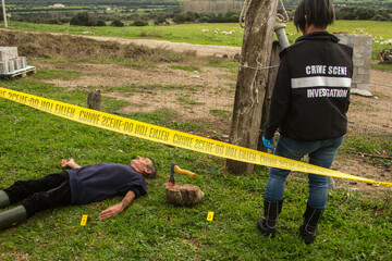 CSI detective at the crime scene examining the crime scene with a dead man lands