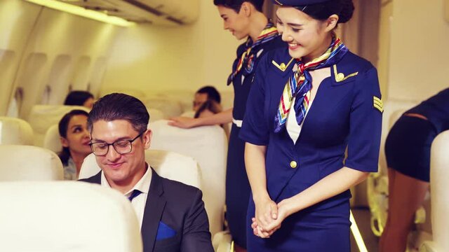 Cabin crew give service to passenger in airplane . Airline transportation and tourism concept.