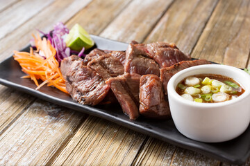 A view of an appetizer plate of crying tiger, a marinated steak Thai dish.