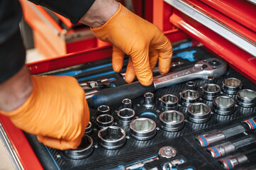 A set of tools for repair in car service - mechanic's hands, close up. High quality photo