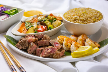 A view of a surf and turf plate, in a restaurant or kitchen setting.