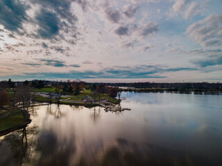Sunset reflections of clouds and trees over Jacobson park lake in Lexington, Kentucky USA