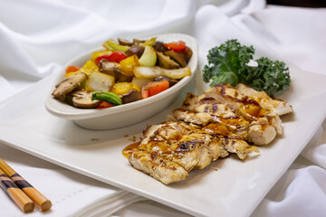 A view of a chicken teriyaki plate, in a restaurant or kitchen setting.