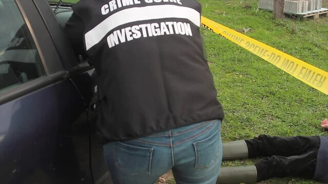 CSI detective at the crime scene examining the crime scene with a tabled in hand