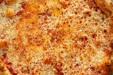 Obraz na płótnie Canvas A top down view of a rustic cheese pizza pie, as a background.