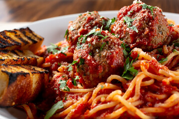 A closeup view of a bowl of spaghetti and meatballs.