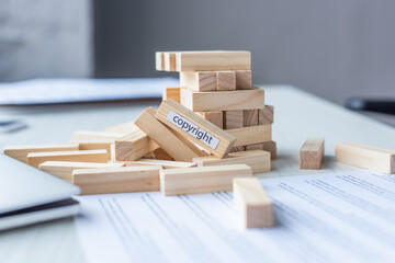 Close up view of blocks wood game constriction collapsing with copyright lettering with blurred...