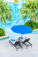 Umbrella and chair around outdoor swimming pool