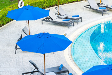 Umbrella and chair around outdoor swimming pool