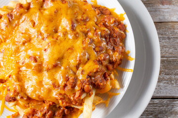 A top down view of a bowl of chili cheese french fries.