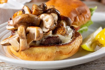 A closeup view of an open face mushroom cheeseburger.