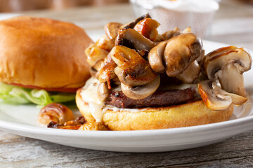 A closeup view of an open face mushroom cheeseburger.