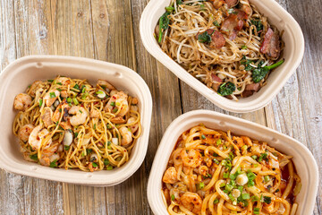 A top down view of several fast casual pan Asian noodle bowls.