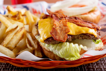 A view of an open face bacon cheeseburger plate.