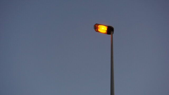 modern streetlight lit against blue background