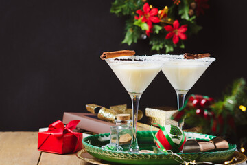 Winter cocktail with coconut flakes  and cinnamon sticks on green tray. Christmas or New Year concept.